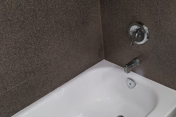 Tub andTile Resurfaced by Epic Resurfacing Solutions. Tile is dark brown in colour and tub is white.